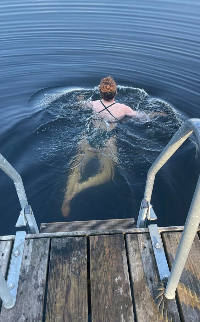 Vrouw zwemmend in het meer van Hotel Dömle Herrgård.