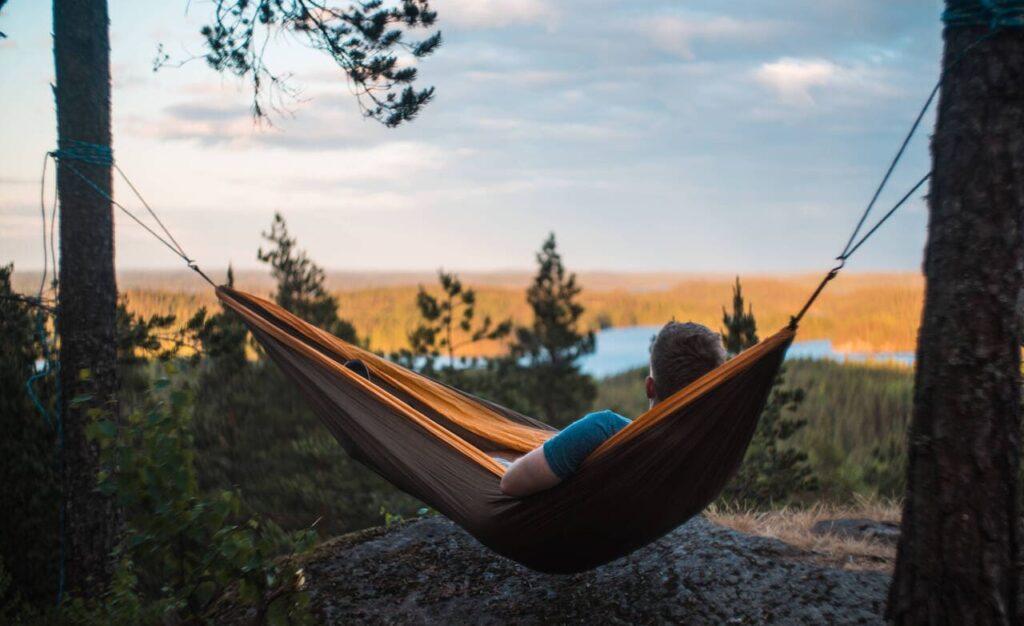 Wandelen Saimaa: de mooiste natuurpaden en nationale parken bij Mikkeli 5 Man in hangmat Neitvuori heuvel Mikkeli - Visit Saimaa